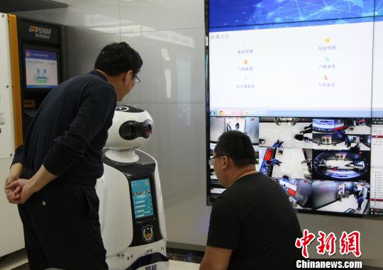 圖為市民正在“無人警局”內(nèi)與機(jī)器人對話。 趙曉 攝