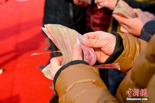 領(lǐng)到錢的農(nóng)民工正在清點(diǎn)工資。 圖片來(lái)源：視覺中國(guó)