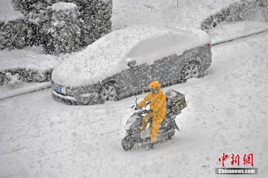 圖為行人在山東省煙臺市福山區(qū)街頭冒雪出行。<a target='_blank' >中新社</a>發(fā) 孫文潭 攝 圖片來源：CNSPHOTO