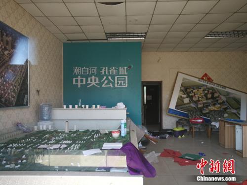 從燕郊一家已經(jīng)關(guān)門的售樓處門外望進去，地上散落著廢紙、條幅，沙盤上放著落灰的殺蟲劑。<a target='_blank'  >中新網(wǎng)</a>記者 邱宇 攝