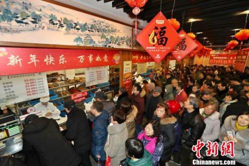 資料圖：民眾排長隊購熟食備年貨。宦瑋 攝