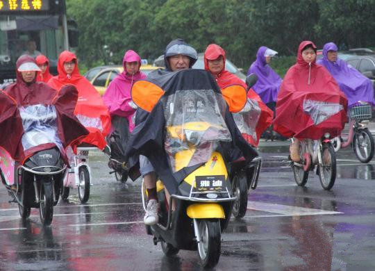 市民騎車在雨中的南京街頭經(jīng)過。李珂 攝