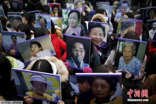 資料圖：韓國首爾民眾高舉慰安婦的照片，在日本使館前集會(huì)抗議。