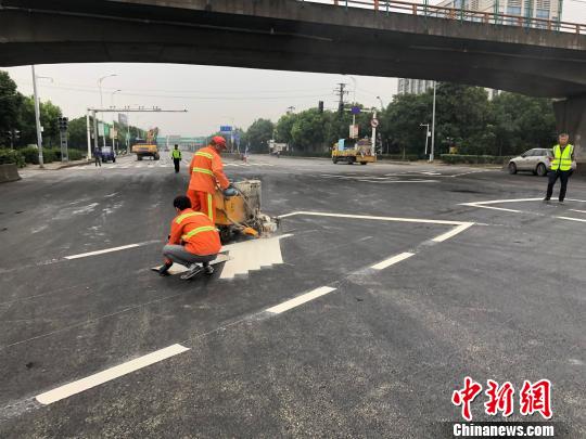 工作人員給事發(fā)路段的地面噴上白色的交通標(biāo)線。 孫權(quán) 攝