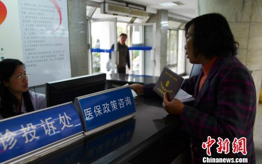 資料圖。一名女子在醫(yī)保政策咨詢臺前咨詢。 王思哲 攝