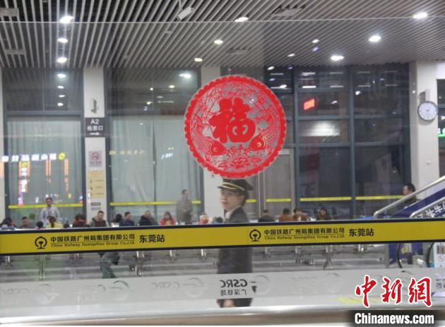 圖為朱益嘉巡視完候車廳望向正在進(jìn)行志愿服務(wù)的丈夫 。廣州車務(wù)段供圖
