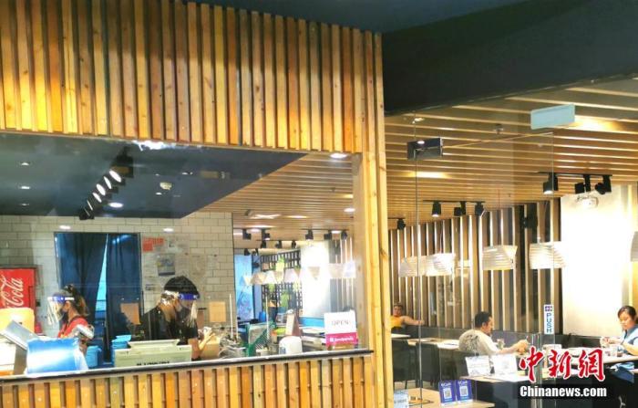 資料圖：6月26日，菲律賓首都馬尼拉餐飲業(yè)堂食“新常態(tài)”恢復(fù)。位于馬尼拉CBD馬卡蒂綠帶商圈餐廳，工作人員戴著口罩和面罩提供服務(wù)。<a target='_blank' >中新社</a>記者 關(guān)向東 攝